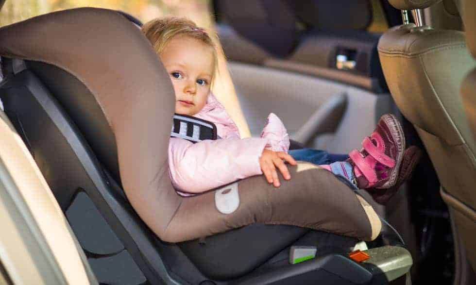 A toddler, safe and secure in her child car seat